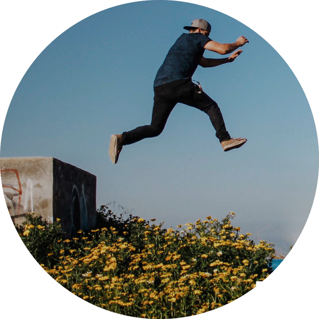 Runder Fotoausschnitt mit jugendlicher Person, die von einer Plattform zur nächsten springt.